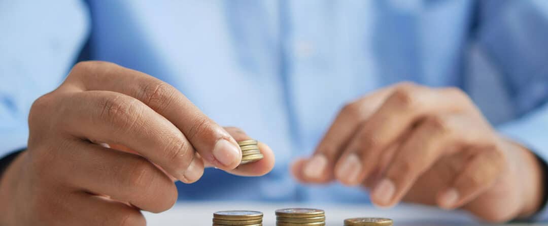 A man counts coins on a table